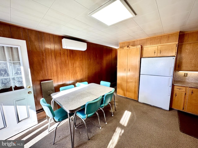 dining space featuring a wall mounted air conditioner, carpet floors, and wood walls