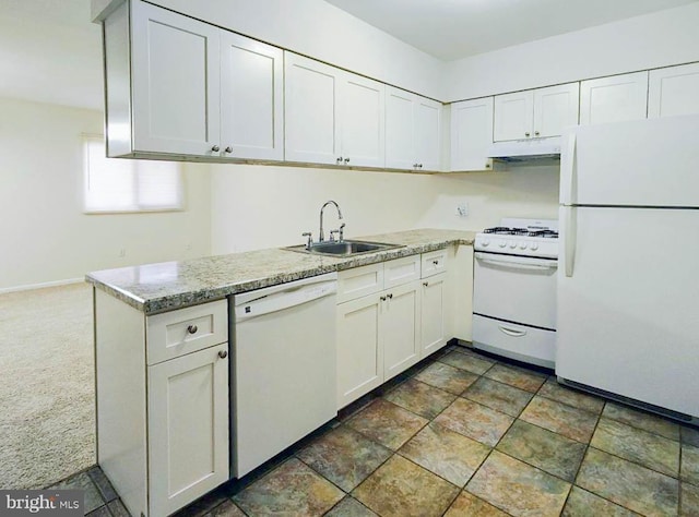 kitchen featuring dark carpet, white appliances, sink, light stone countertops, and white cabinetry