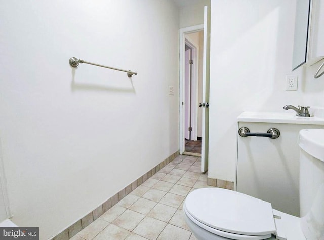 bathroom with toilet, tile patterned floors, and sink