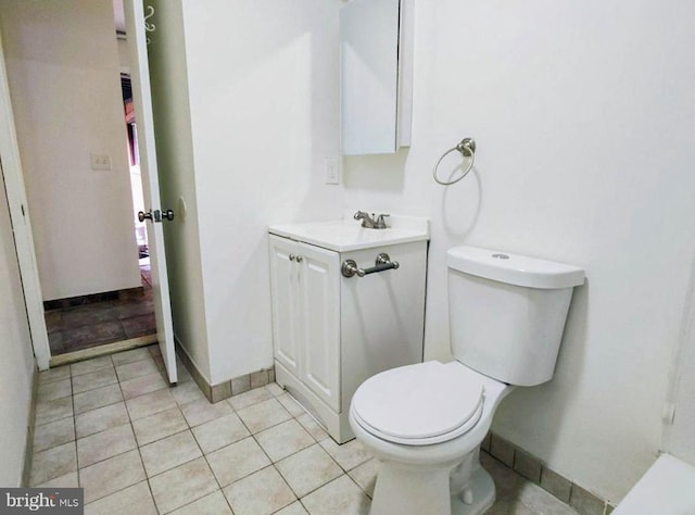 bathroom featuring tile patterned flooring, vanity, and toilet