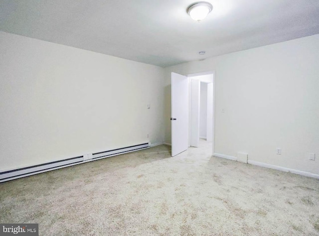 spare room with light colored carpet and a baseboard heating unit