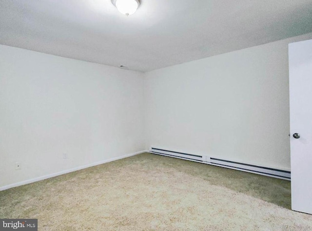 empty room with a textured ceiling, light colored carpet, and a baseboard heating unit