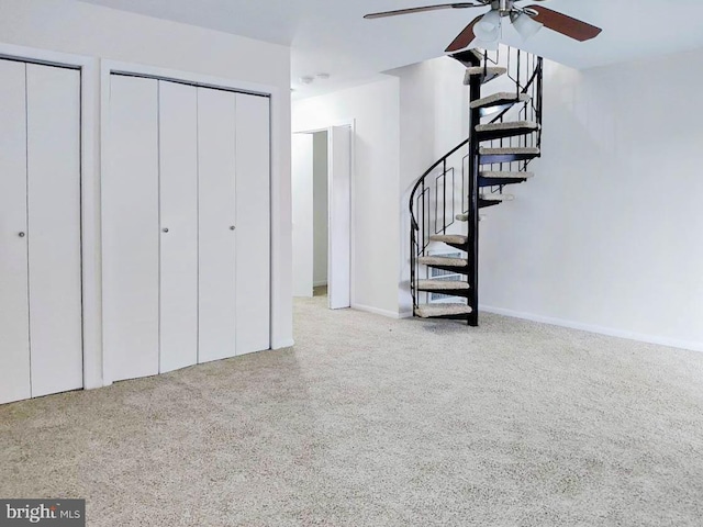 interior space with ceiling fan, carpet floors, and two closets