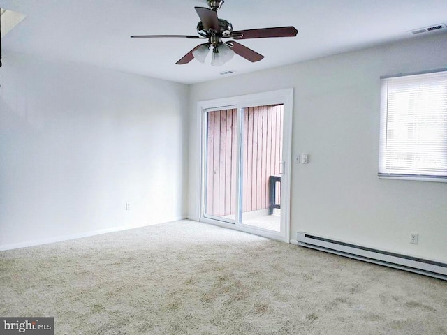 spare room featuring ceiling fan, baseboard heating, and light carpet