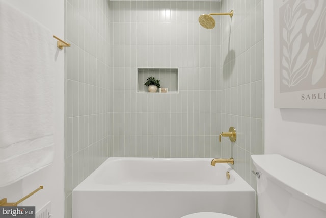 bathroom featuring tiled shower / bath combo and toilet