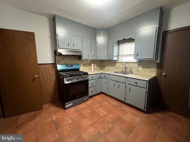 kitchen with backsplash, gray cabinets, sink, and stainless steel range with gas stovetop