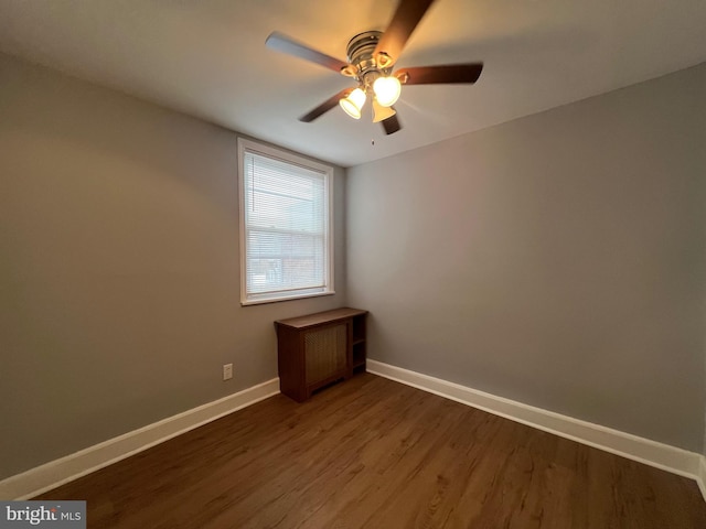 spare room featuring ceiling fan and dark wood-type flooring