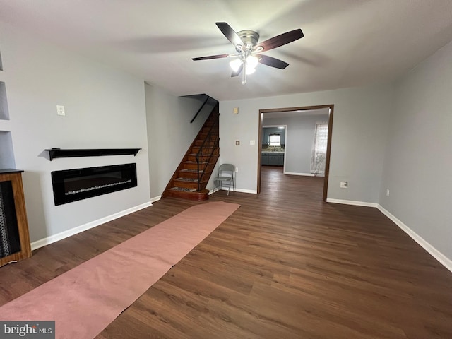 unfurnished living room featuring dark hardwood / wood-style flooring and ceiling fan