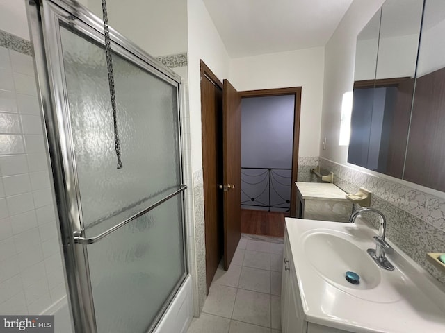 bathroom featuring tile patterned floors, vanity, and enclosed tub / shower combo