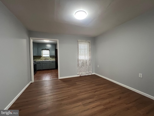 spare room with dark hardwood / wood-style flooring and sink