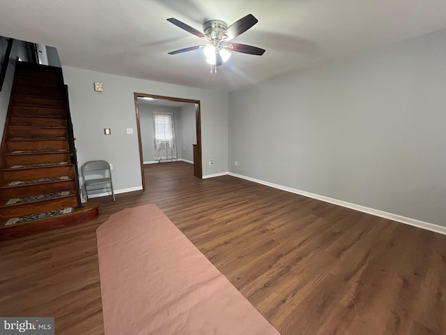 unfurnished living room with dark hardwood / wood-style flooring and ceiling fan