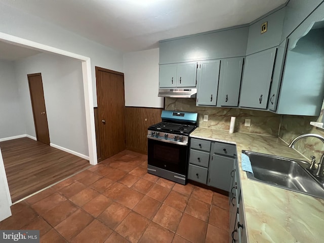 kitchen featuring gas range, backsplash, dark hardwood / wood-style floors, and sink