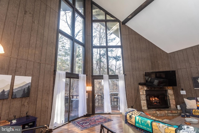 living room featuring wooden walls, hardwood / wood-style flooring, and high vaulted ceiling