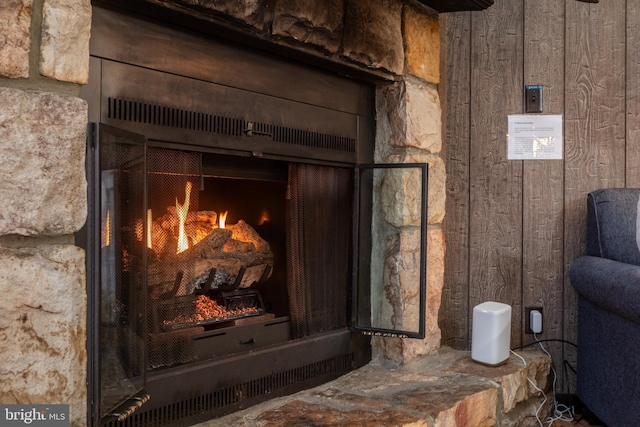 room details featuring wooden walls and a fireplace