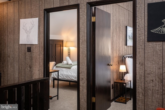 bedroom featuring wooden walls and carpet