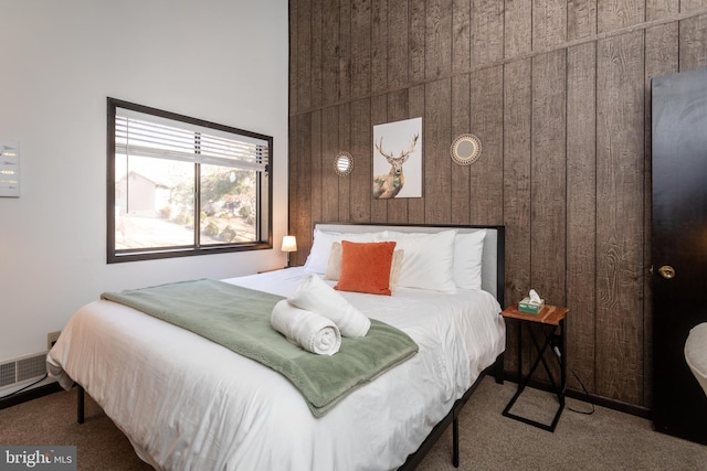 carpeted bedroom with wood walls