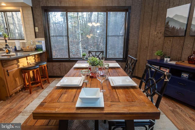 dining area featuring hardwood / wood-style floors and wooden walls