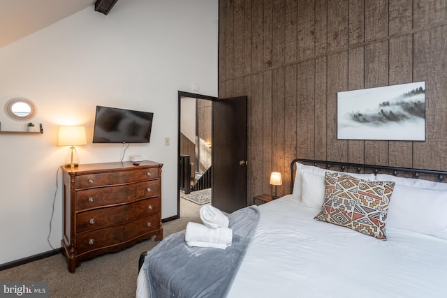 carpeted bedroom featuring wood walls and vaulted ceiling