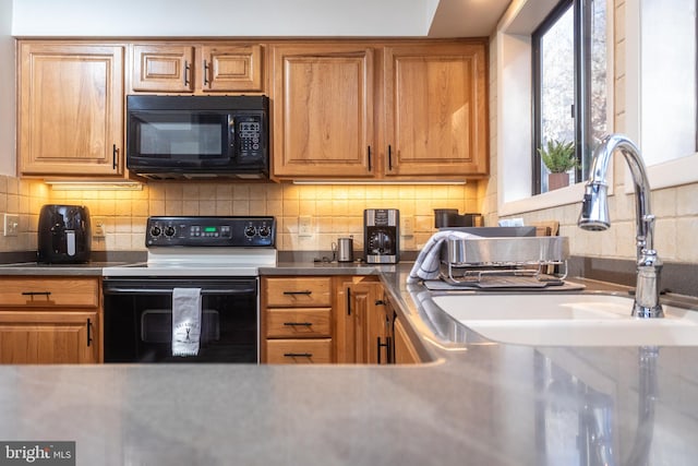 kitchen featuring black appliances, sink, and tasteful backsplash