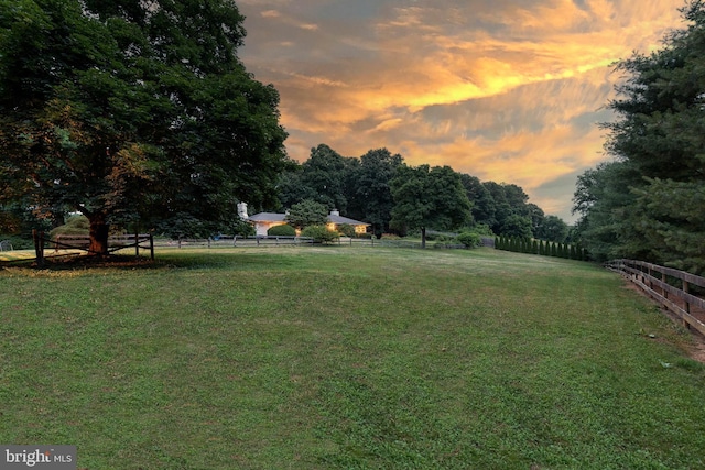 yard at dusk featuring a rural view