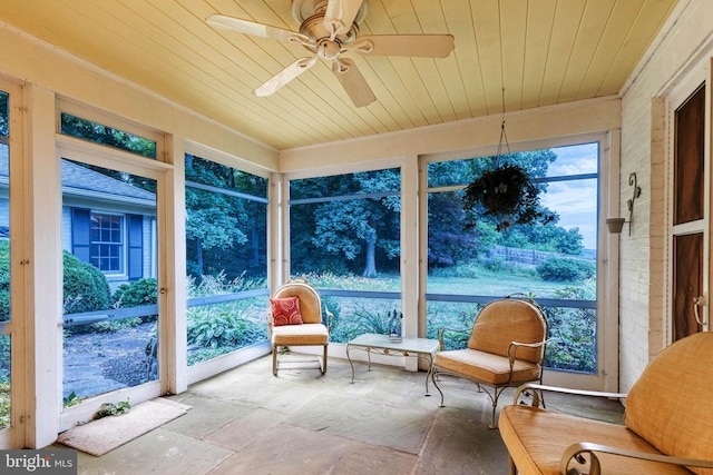 sunroom with ceiling fan and wooden ceiling