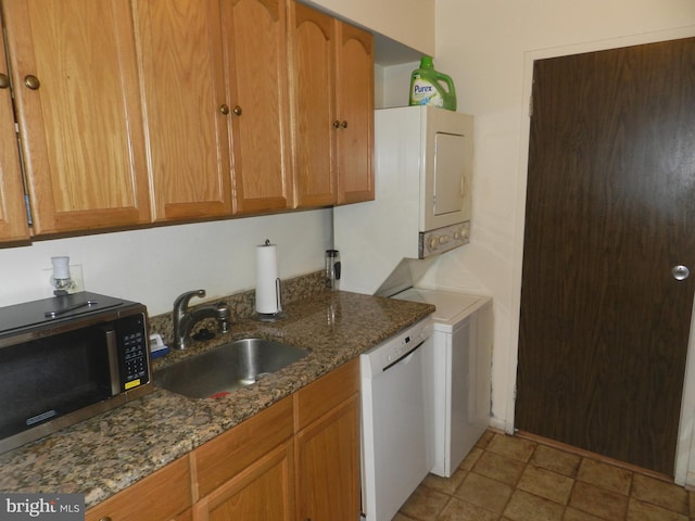 kitchen featuring sink, dishwasher, and dark stone counters