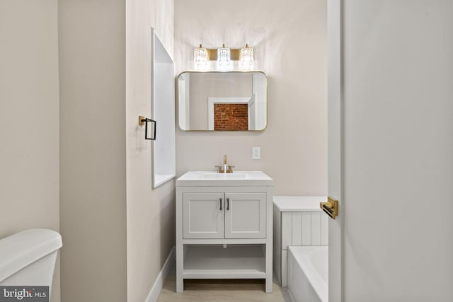 bathroom featuring a bathing tub, vanity, and toilet