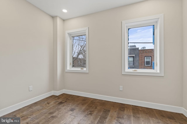 spare room with a healthy amount of sunlight and hardwood / wood-style floors