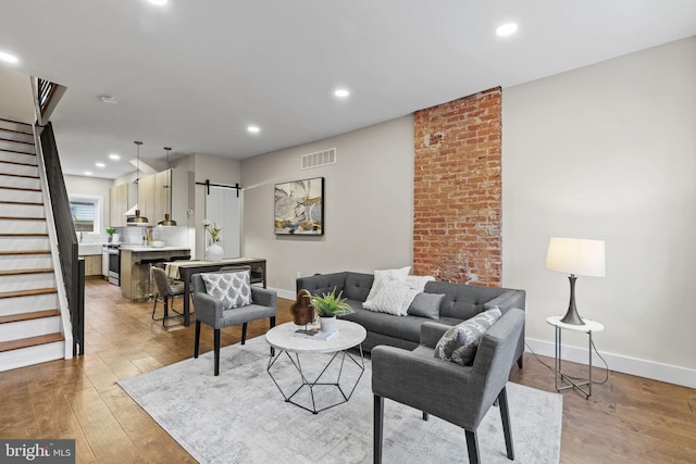 living room featuring light hardwood / wood-style floors and a barn door