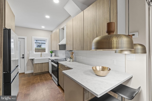 kitchen with kitchen peninsula, electric stove, dark hardwood / wood-style floors, a kitchen breakfast bar, and sink