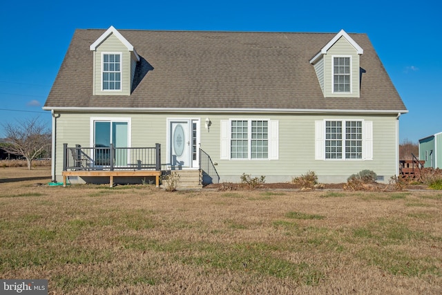 cape cod home featuring a wooden deck and a front yard