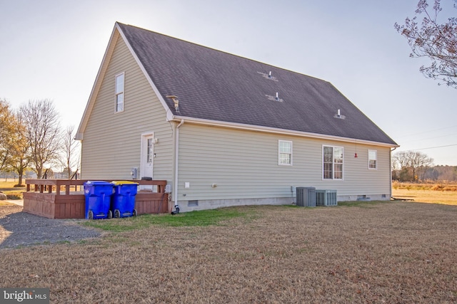 rear view of house featuring cooling unit and a yard