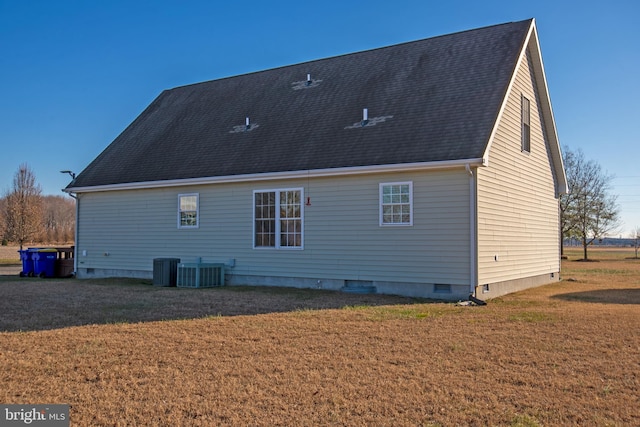 back of house with cooling unit and a yard