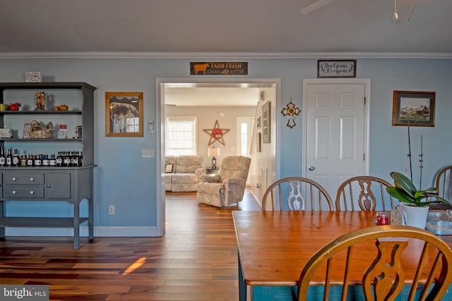 dining space featuring dark hardwood / wood-style floors and ornamental molding