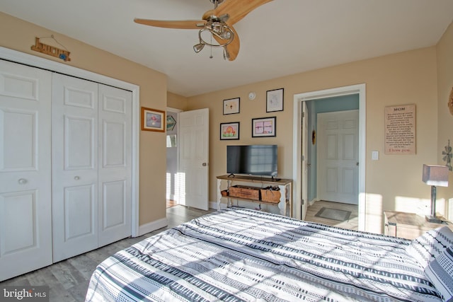 bedroom featuring ceiling fan, a closet, and light wood-type flooring