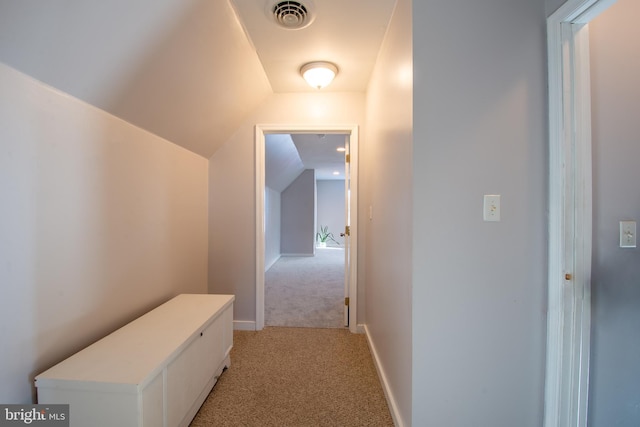 corridor with lofted ceiling and light carpet