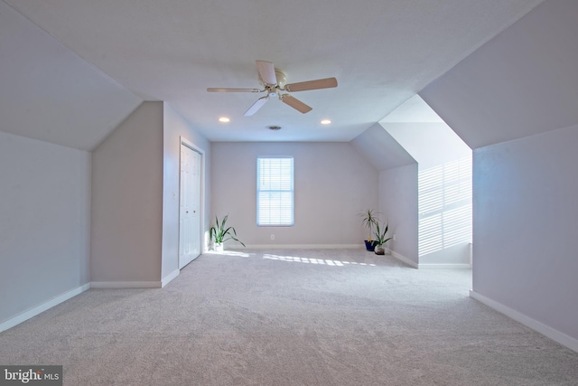 additional living space featuring ceiling fan, light colored carpet, and vaulted ceiling