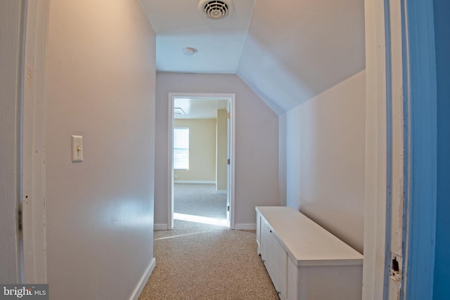 hallway with light colored carpet and vaulted ceiling