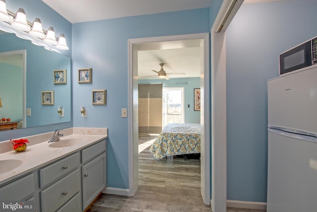 bathroom featuring ceiling fan, wood-type flooring, and vanity