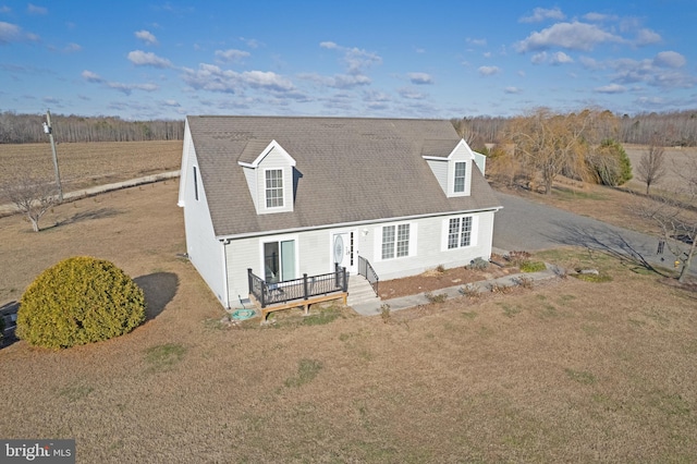 cape cod-style house featuring a front yard and a wooden deck