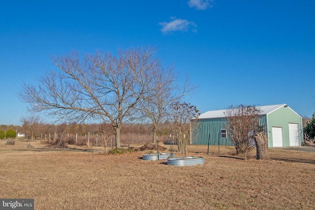 view of yard featuring a garage and an outbuilding