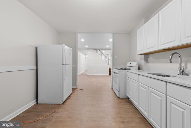 kitchen featuring light wood-type flooring, white appliances, white cabinetry, and sink