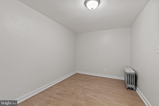 empty room with radiator and light hardwood / wood-style floors