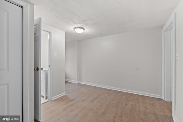 hall featuring a textured ceiling and light hardwood / wood-style floors