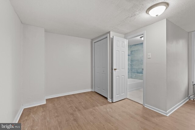 unfurnished bedroom featuring a textured ceiling and light wood-type flooring