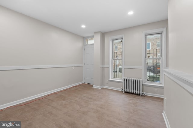 spare room featuring radiator heating unit and plenty of natural light