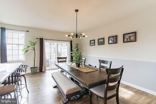 dining area featuring a chandelier, wood-type flooring, and a healthy amount of sunlight