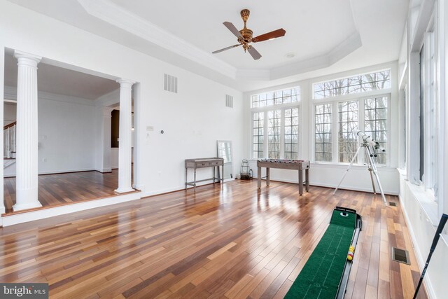 exercise room featuring french doors, ornamental molding, a tray ceiling, ceiling fan, and hardwood / wood-style floors