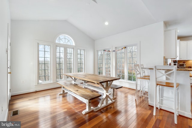 dining area with lofted ceiling and light hardwood / wood-style flooring