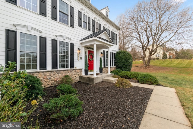 doorway to property featuring a yard